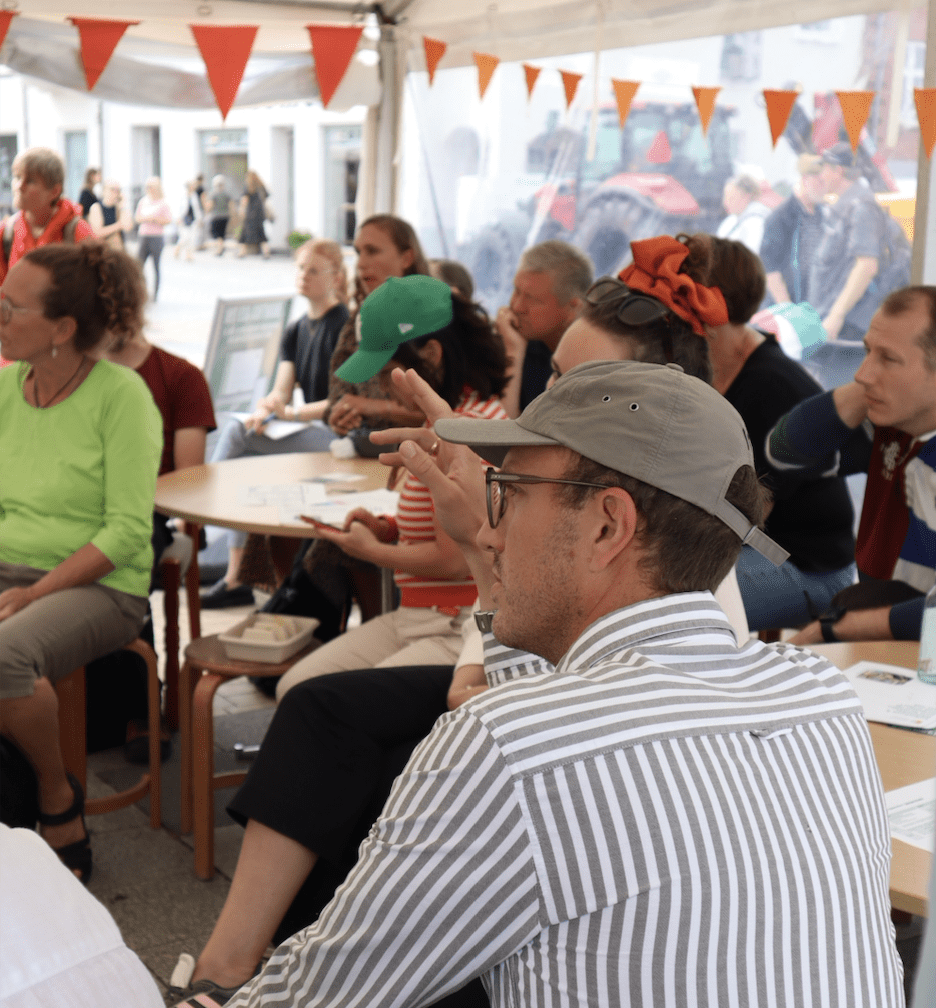 ESG365 deltager ved Folkemødet 2024 på Bornholm. Her deltages der ved et oplæg, hvor en mand rækker hånden op